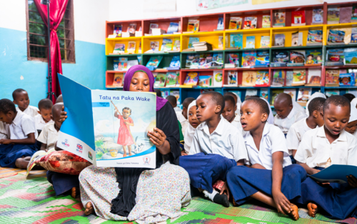 Literacy Program teacher reading local language book to students