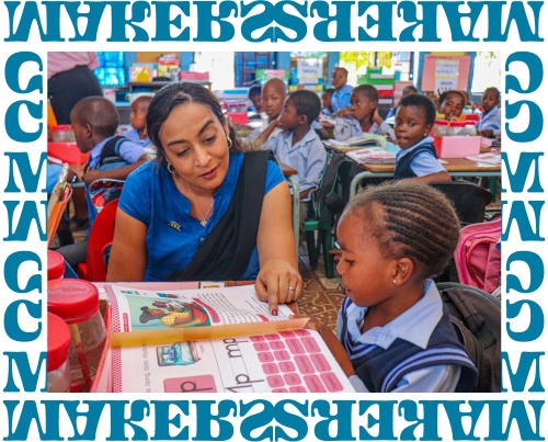 CEO Geetha Murali reading a book with a student in a South African classroom