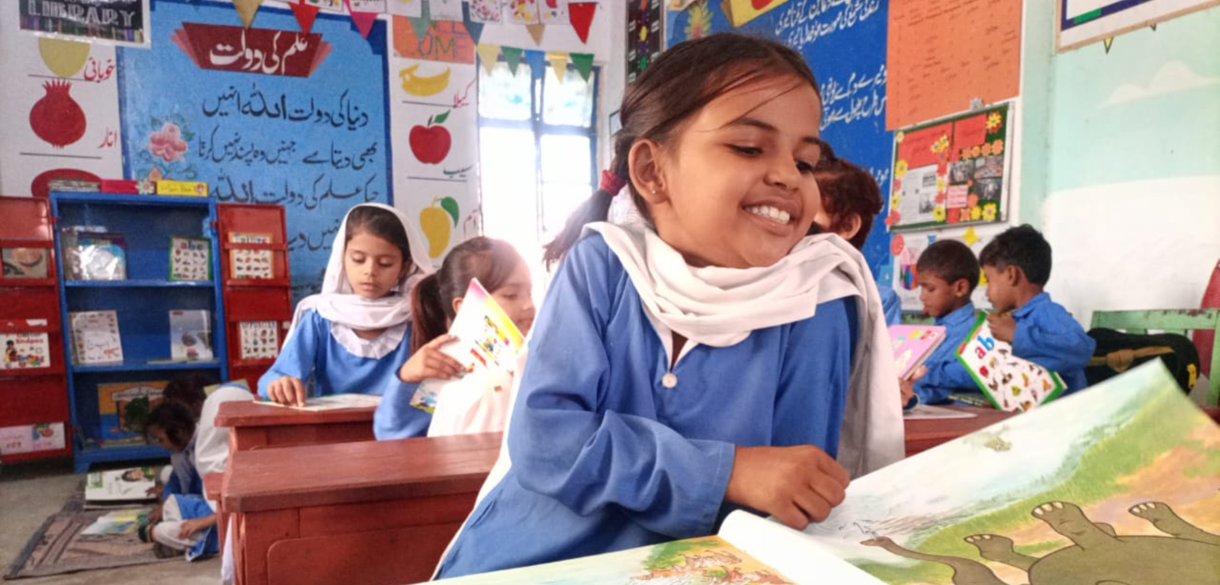Education in Pakistan, a child expresses joy while reading