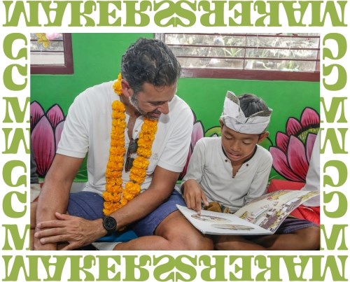 Yusuf Alireza is sitting next to a Indonesian student and reading a book together.