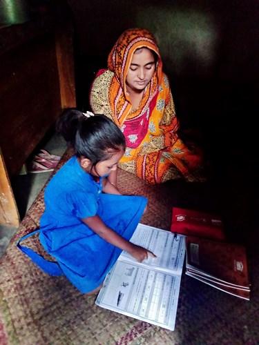 Nagris helps her daughter learn to read and write with Room to Read deliveries