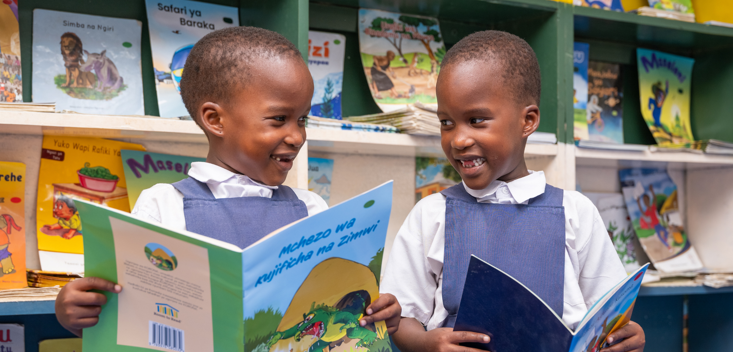Promoting book use in a digital world in a school library in Tanzania where who children explore books pulled from colorful library shelves.