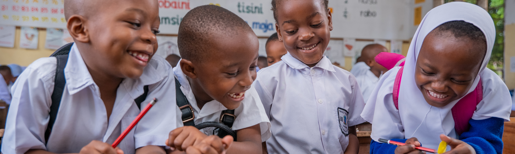 Education nonprofits children laughing in a Room to Read-supported classroom in Tanzania