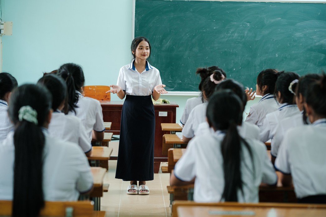 How to support girls' education, a girl standing in front of her class