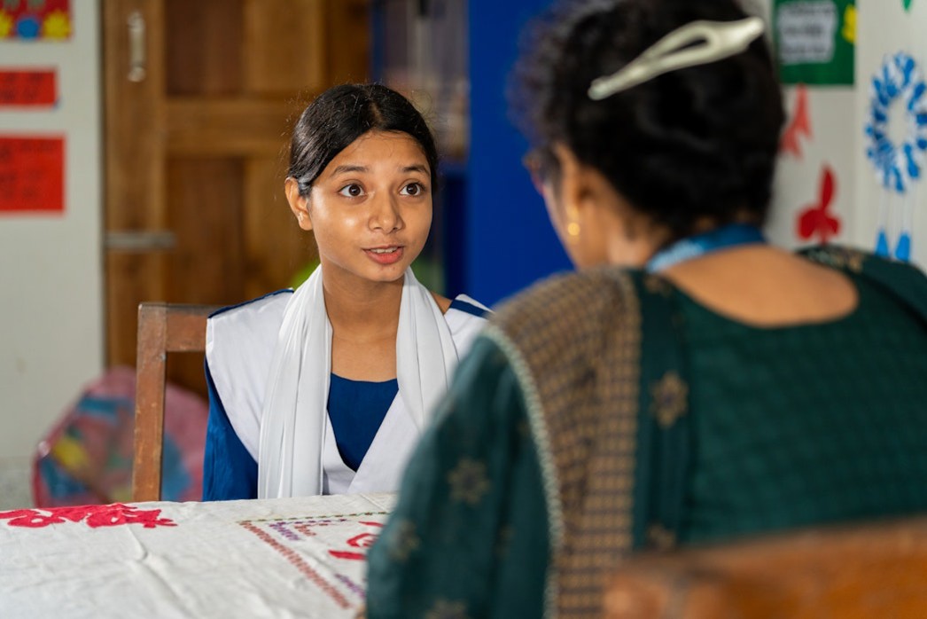 Equity in education, a female student talking with her teacher about her progress