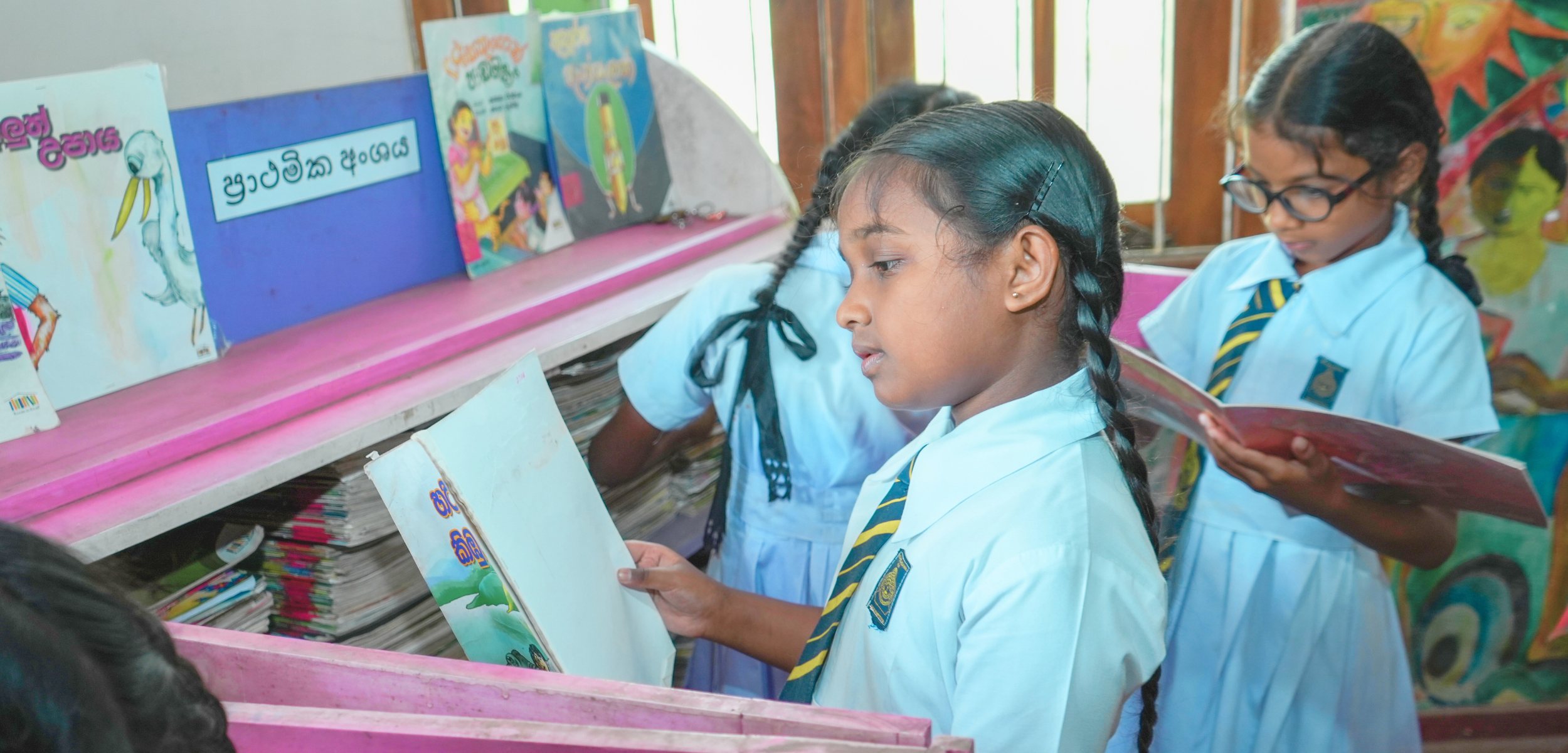 How to motivate kids to read, girls selecting books from a Room to Read library in Sri Lanka