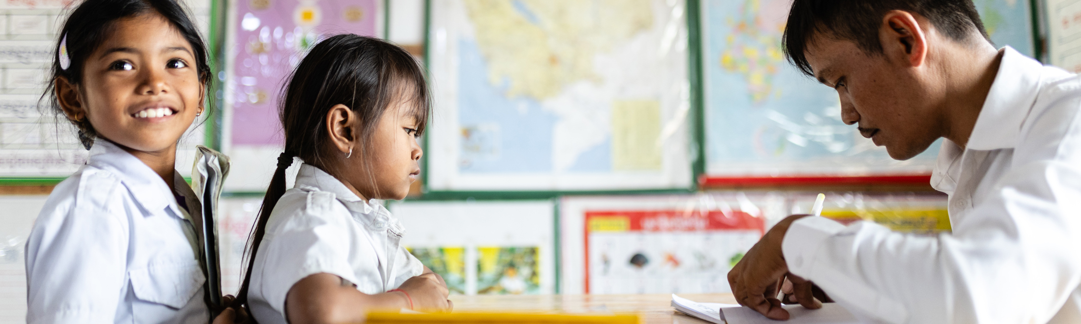 Education nonprofits children checking out books from a Room to Read library in Cambodia