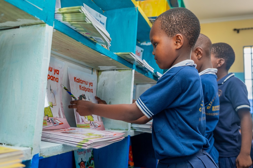 How to achieve equity in education, a student choosing a book from a classroom library