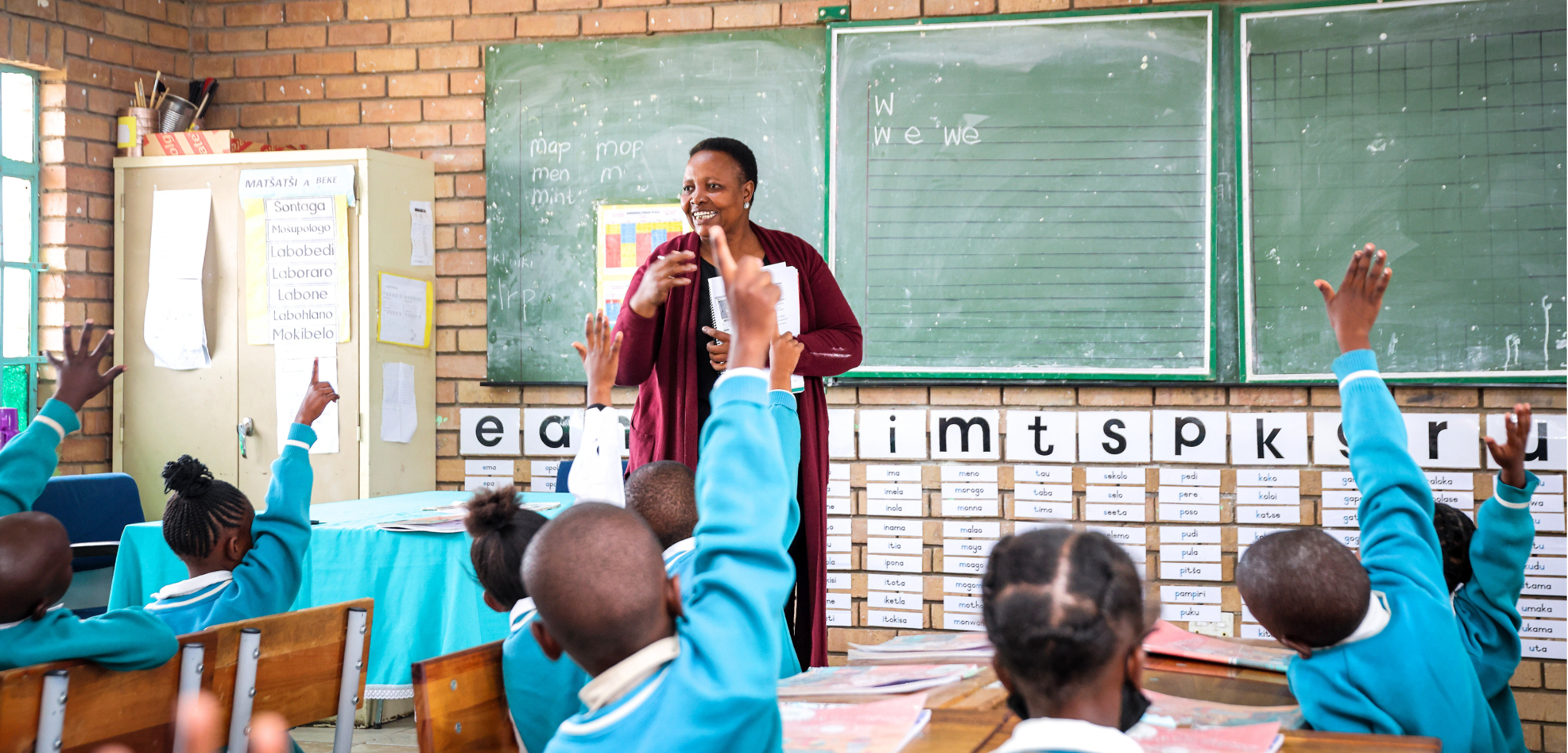 A teacher in a Room to Read-supported classroom in South Africa answers questions from children.