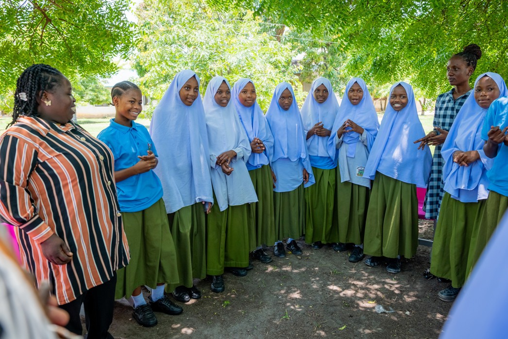 Empowering girls, a teacher mentoring students outside a Room to Read school
